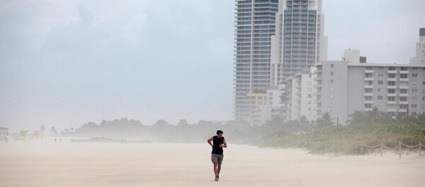 Una persona camina por la playa antes de la llegada del huracán Matthew en Miami Beach Una persona camina por la playa antes de la llegada del huracán Matthew en Miami Beach - Sputnik Mundo