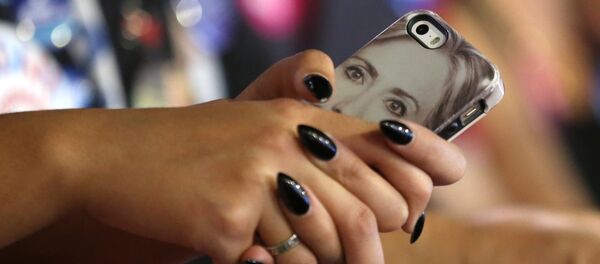 Celular con la imagen de Hillary Clinton - Sputnik Mundo