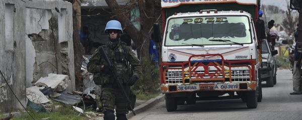 UN soldiers provide security for trucks from the UN's World Foof Programme in Port Salut southwest of Port-au-Prince, on October 12, 2016, following the passage of Hurricane Matthew. The first major handout of food aid took place along Haiti's storm-wrecked southwest coast but supplies were still far short of what was needed by the thousands of starving people. - Sputnik Mundo