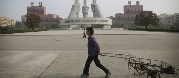 North Korean women walk past a monument built 11 years ago to honor the founding of the Workers' Party of North Korea on Saturday, Oct. 15, 2016, in Pyongyang, North Korea - Sputnik Mundo