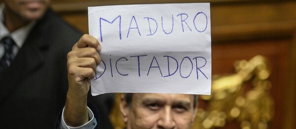 A Venezuelan opposition deputy holds up a sing reading  Maduro dictator during an extraoridinary session of the National Assembly, in Caracas on October 23, 2016. - Sputnik Mundo