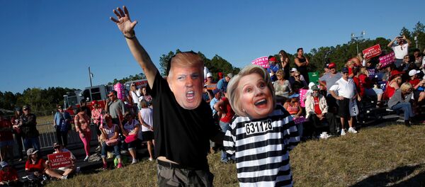 Craig Wendel dresses as Republican U.S. presidential nominee Donald Trump and his wife Jill Wendel wears a Hillary Clinton mask as they support Trump at a campaign rally in Naples, Florida, U.S. October 23, 2016 - Sputnik Mundo