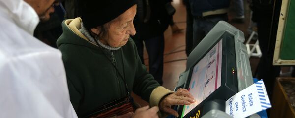Una anciana argentina usando una máquina de voto electrónico (archivo) - Sputnik Mundo
