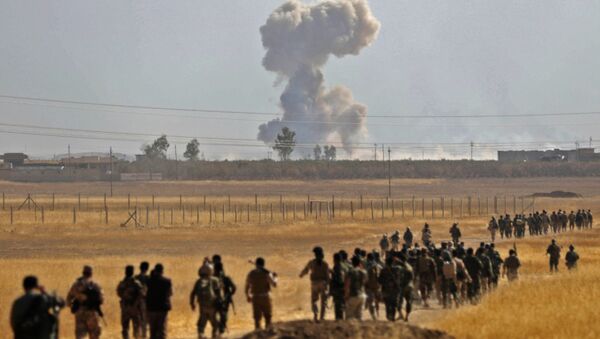 Smoke billows from an area near the Iraqi town of Nawaran, some 10km north east of Mosul, as Iraqi Kurdish Peshmerga fighters march down a dirt road on October 20, 2016, during the ongoing operation to retake the city from the Islamic State (IS) group - Sputnik Mundo