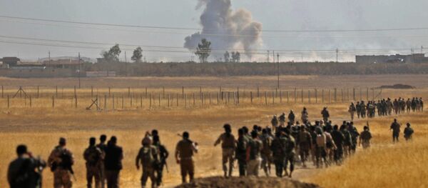 Smoke billows from an area near the Iraqi town of Nawaran, some 10km north east of Mosul, as Iraqi Kurdish Peshmerga fighters march down a dirt road on October 20, 2016, during the ongoing operation to retake the city from the Islamic State (IS) group - Sputnik Mundo