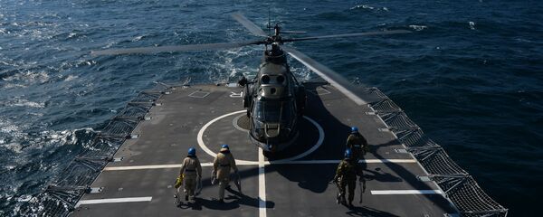 Romanian frigate Regina Maria personnel with the NATO Standing Maritime Group-2 maintain a helicoper which just landed on the heliport of the ship during a military drill on the Black Sea, 60km from Constanta city March 16, 2015 - Sputnik Mundo