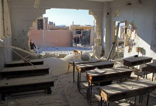 Se ve que quedó dañado solo un muro lateral del edificio mientras que los pupitres en el aula ni siquiera fueron desplazados. Además, una valla ubicada enfrente del colegio no sufrió ningún daño, algo que no puede ser Se ve que quedó dañado solo un muro lateral del edificio mientras que los pupitres en el aula ni siquiera fueron desplazados. Además, una valla ubicada enfrente del colegio no sufrió ningún daño, algo que no puede ser - Sputnik Mundo