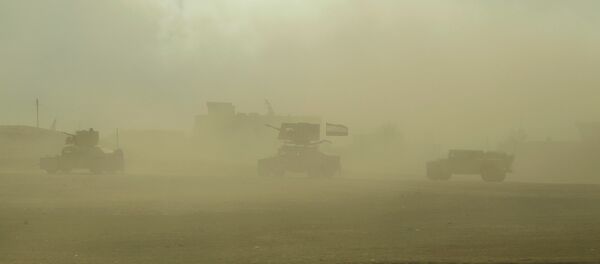 Iraqi army vehicles drive through fumes from a nearby sulfur plant set alight by Islamic State militants, at south of Mosul in Qayyara - Sputnik Mundo
