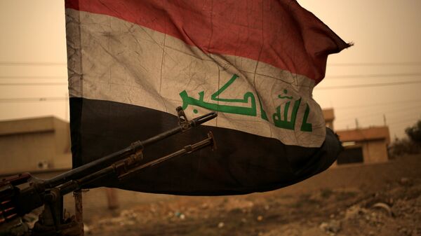 Iraq's flag is seen during a sand storm in Bartilla, east of Mosul - Sputnik Mundo