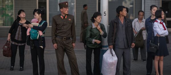 La gente esperando el autobús en una parada de Pyongyang, Corea del Norte La gente esperando el autobús en una parada de Pyongyang, Corea del Norte - Sputnik Mundo