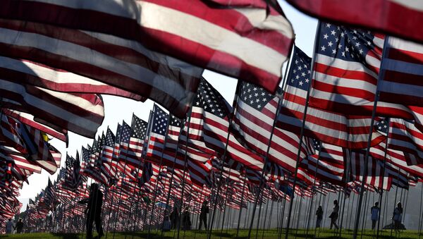 People walk amongst US national flags erected by students and staff from Pepperdine University as they pay their respects to honor the victims of the September 11, 2001 attacks in New York, at their campus in Malibu, California - Sputnik Mundo