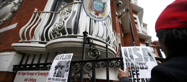 A supporter of Julian Assange attaches a poster to railings after prosecutor Ingrid Isgren from Sweden arrived at Ecuador's embassy A supporter of Julian Assange attaches a poster to railings after prosecutor Ingrid Isgren from Sweden arrived at Ecuador's embassy - Sputnik Mundo