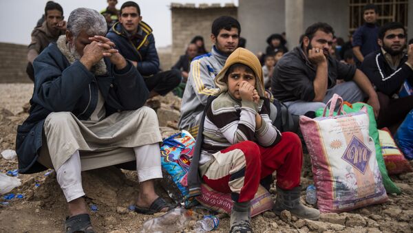 Iraqis fleeing the fighting rest as they reach an area held by Iraqi Special Forces 2nd division for transport out of the combat zone in the Samah neighbourhood of Mosul on November 15, 2016 - Sputnik Mundo