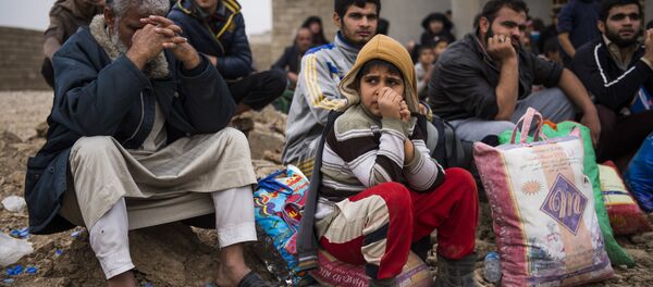 Iraqis fleeing the fighting rest as they reach an area held by Iraqi Special Forces 2nd division for transport out of the combat zone in the Samah neighbourhood of Mosul on November 15, 2016 - Sputnik Mundo