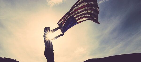 Un hombre con la bandera de EEUU - Sputnik Mundo