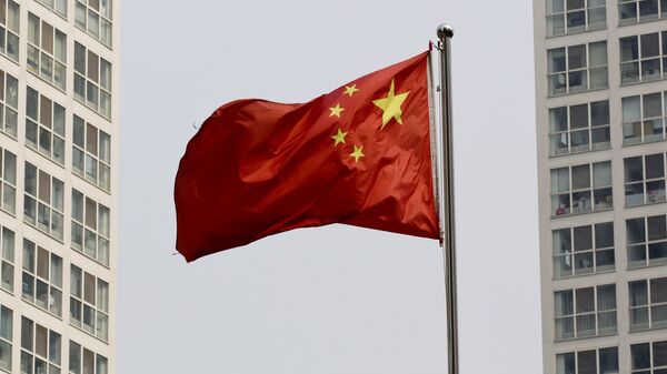 A Chinese national flag flutters in the wind in between a high-rise residential and office complex in Beijing, China. (File) - Sputnik Mundo