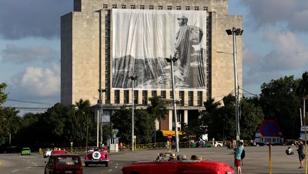 Fusil y mochila a la espalda en la Sierra Maestra, el líder histórico de la Revolución cubana, Fidel Castro, preside desde una gigantografía el homenaje póstumo de cubanos y extranjeros - Sputnik Mundo