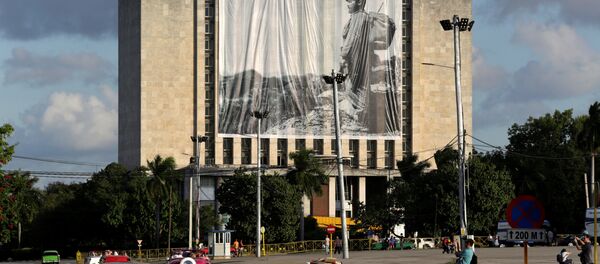 Fusil y mochila a la espalda en la Sierra Maestra, el líder histórico de la Revolución cubana, Fidel Castro, preside desde una gigantografía el homenaje póstumo de cubanos y extranjeros - Sputnik Mundo