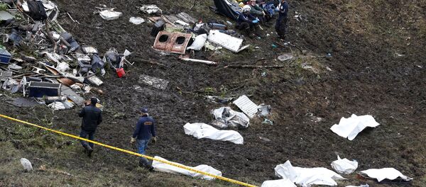 Rescue workers walk next to bodies from the wreckage of a plane that crashed into the Colombian jungle with the Brazilian soccer team Chapecoense onboard near Medellin, Colombia - Sputnik Mundo