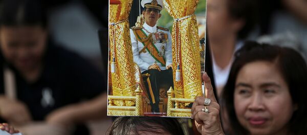 Una mujer con el retrato del nuevo rey de Tailandia - Sputnik Mundo