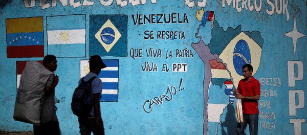 Venezuelan citizens walk past graffiti referencing Mercosul in Caracas, Venezuela - Sputnik Mundo