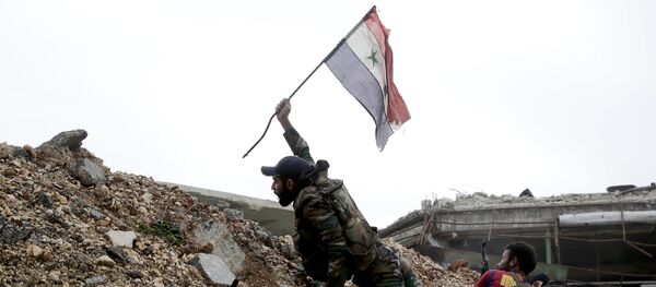 Militar sirio emplaza la bandera nacional de Siria durante los combates en Alepo oriental - Sputnik Mundo