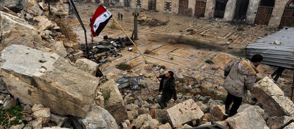 A member of forces loyal to Syria's President Bashar al-Assad attempts to erect the Syrian national flag inside the Umayyad mosque, in the government-controlled area of Aleppo, during a media tour, Syria - Sputnik Mundo