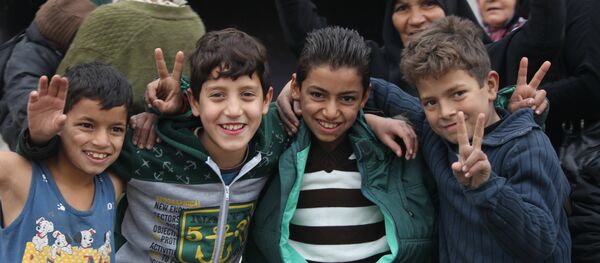 Niños que celebran la liberación en Hanano, este de Alepo - Sputnik Mundo