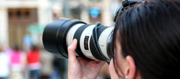 Una mujer con cámara - Sputnik Mundo