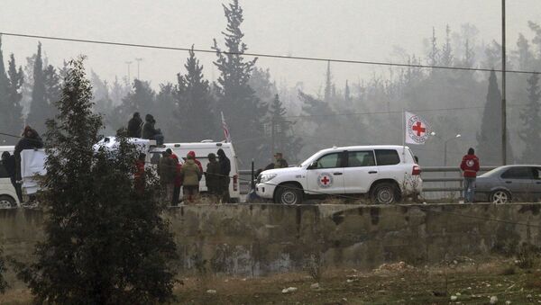 In this photo released by the Syrian official news agency SANA, civilians gather near the Red Cross vehicles for evacuation from eastern Aleppo, Syria, Friday, Dec. 16, 2016. - Sputnik Mundo