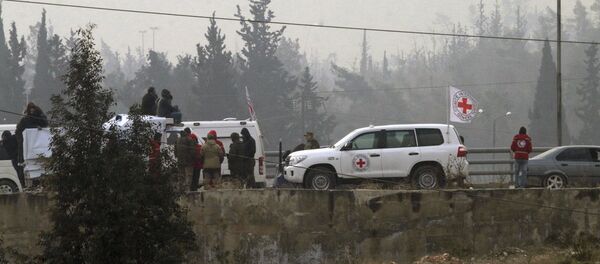 In this photo released by the Syrian official news agency SANA, civilians gather near the Red Cross vehicles for evacuation from eastern Aleppo, Syria, Friday, Dec. 16, 2016. - Sputnik Mundo