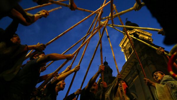 Mapuche Indian activists raise their sticks during a demonstration to demand justice for indigenous Mapuche inmates as well as for their indigenous rights and land for their communities in Santiago - Sputnik Mundo