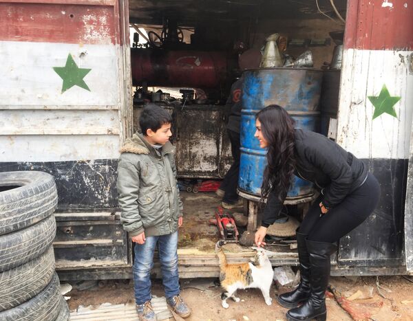 La cineasta boliviana Carla Ortiz junto a un niño en Siria - Sputnik Mundo