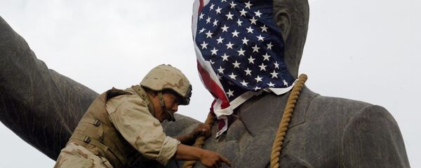 A US Marine covers the head of a statue of Iraqi President Saddam Hussein with the US flag before pulling it down in Baghdad's al-Fardous (paradise) square 09 April 2003 as the marines swept into the Iraqi capital and the Iraqi leader's regime collapsed. - Sputnik Mundo