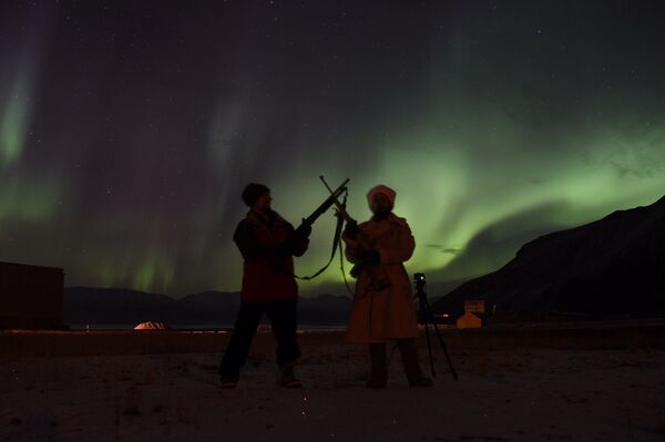 Sasha con su colega-guía con aurora boreal de fondo - Sputnik Mundo