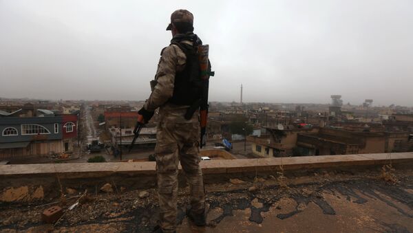 An Iraqi security member stands guard as Iraqi Christians attend a Christmas Eve service at the Saint John's church (Mar Yohanna church) in the town of Qaraqosh (also known as Hamdaniya), 30 kms east of Mosul, on December 25, 2016 - Sputnik Mundo