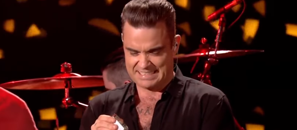 Robbie Williams se desinfecta las manos después de tocar a sus fans - Sputnik Mundo