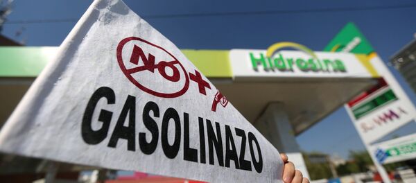 Un hombre sostiene un letrero durante una manifestación contra el aumento de los precios de la gasolina en Ciudad de México - Sputnik Mundo