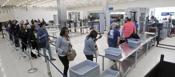 Passengers load their items into bins as they pass through security before flying out of the Fort Lauderdale-Hollywood International Airport, Friday, Dec. 18, 2015 - Sputnik Mundo