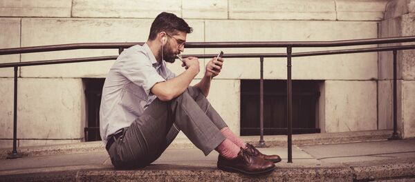 Un hombre con un smartphone (archivo) - Sputnik Mundo