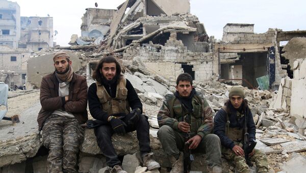 Rebel fighters sit on the rubble of damaged buildings as they wait to be evacuated from a rebel-held sector of eastern Aleppo - Sputnik Mundo