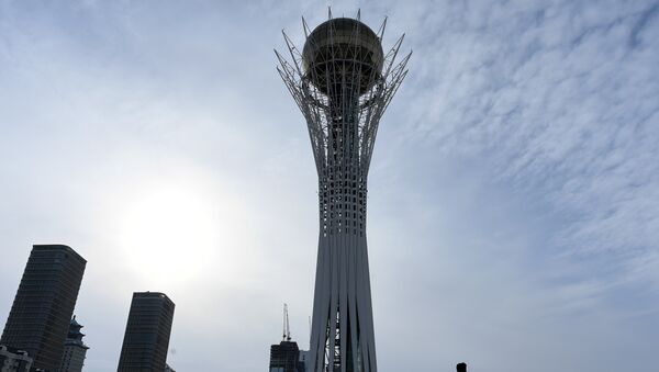 A picture taken on January 22, 2017 shows a man walking in downtown Astana, with the Baiterek monument seen in the background - Sputnik Mundo