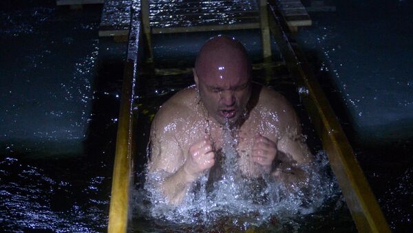 Los ortodoxos rusos celebran la Epifanía con un chapuzón en las aguas heladas del río - Sputnik Mundo