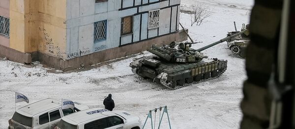 The Organization for Security and Cooperation in Europe (OSCE) cars and tanks are seen in the government-held industrial town of Avdiyivka - Sputnik Mundo