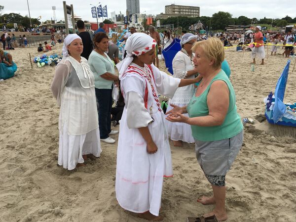 Una mae escucha a una mujer durante la fiesta de Yemayá en Montevideo - Sputnik Mundo