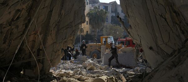 Civil defense members work at a site hit by airstrikes in the rebel-held city of Idlib, Syria Civil defense members work at a site hit by airstrikes in the rebel-held city of Idlib, Syria - Sputnik Mundo