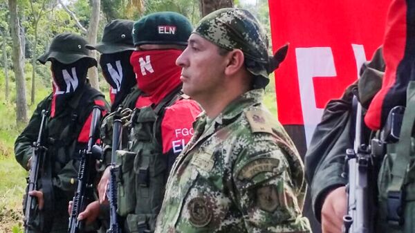 Colombian Soldier Fredy Moreno (R) who was kidnaped by National Liberation Army (ELN), is seen next to ELN members, before his release in Arauca, Colombia on February 6 2017 - Sputnik Mundo