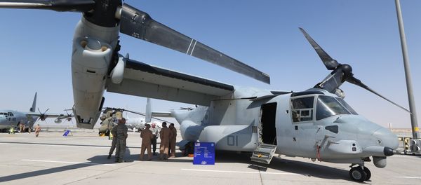 US soldiers stand in the shade of the wing of a Bell Boeing V-22 Osprey, a US multi-mission, tiltrotor military aircraft, displayed at the Dubai Airshow on November 8, 2015 - Sputnik Mundo