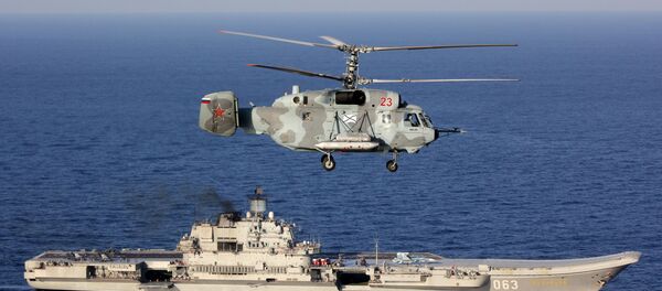 Un Ka-29, con el Almirante Kuznetsov de fondo, en el Mediterráneo - Sputnik Mundo
