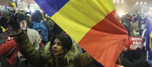 A woman waves a Romanian flag during a protest of thousands against their government in Bucharest, Romania, February 6, 2017 - Sputnik Mundo